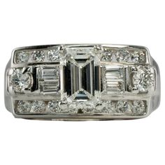 This gorgeous Vintage elegant ring is finely crafted in solid 14K White Gold and set with white and fiery genuine diamonds. The center emerald cut diamond is .50 carat. Four diamond baguettes .20 carats. Eighteen round brilliant cut diamonds total .44 carats. The diamonds are VS1 clarity and FG color for a grand total of (1.14cttw) The top of this genuine diamond ring measures 9mm North-South. The setting elevates 9mm high above the finger. This stylish ring is size 7.25 (can be resized) Total w Diamond Ring With Baguette Diamonds In Octagon Shape, Dazzling Emerald Cut Rings With Baguette Diamonds, Octagon White Gold Diamond Ring With Baguette Diamonds, White Gold Octagon Diamond Ring With Baguette Diamonds, White Gold Octagon Diamond Ring With Baguettes, Fine Jewelry Emerald Cut Diamond Ring With Baguette Diamonds, Octagon Shaped Ring With Baguette Diamonds For Anniversary, Octagon Ring With Baguette Diamonds For Anniversary, Octagon Anniversary Ring With Baguette Diamonds