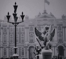 an angel statue in front of a building and street light on a foggy day