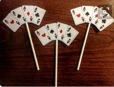 four playing cards are on top of sticks