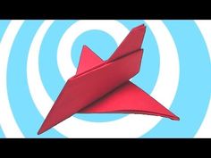 a red origami airplane flying through the air