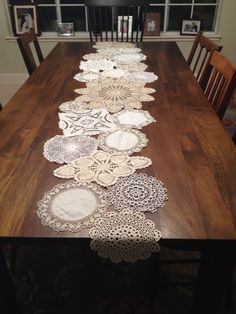 a long table with doily on it in the middle of a dining room area