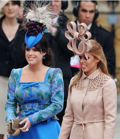 two women in matching outfits standing next to each other with hats on their head and one wearing a blue dress