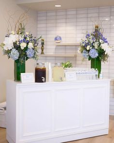 two vases filled with flowers sitting on top of a counter