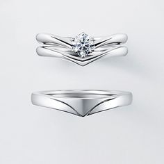 two wedding bands with a single diamond in the middle, and one on top of each other