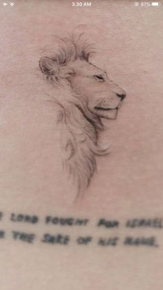 the back of a woman's stomach with a lion tattoo on it, and an inscription