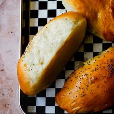 two loaves of bread sitting on top of a checkered tray