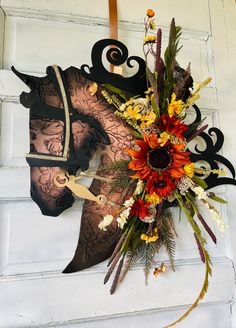 a mask with flowers and scissors hanging on a door