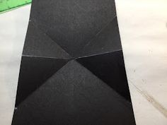 an umbrella made out of black paper sitting on top of a piece of construction paper