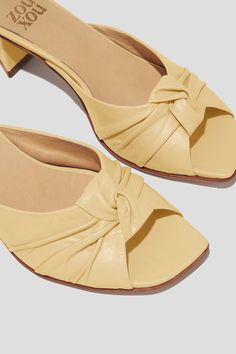 The Greta is a boudoir slipper-inspired mule that captures a playful mix of daytime sensibility & evening refinement. Whether you’re wearing the Greta for daytime play or after-dark doings, you will feel both comfortable and well-turned-out, thanks to a low, triangular heel and a pretty pleated-knot detail at the toe. Style Greta back to loose, casual pants for a breezy date look, or wear them with a cocktail dress to the next wedding on your calendar. Kidskin leather upper, vegetable tanned leather lining, leather outsole. Heel height: 1 ¾ inches (45 mm) Handmade in Argentina Summer Evening Closed Toe Mules, Summer Evening Mules With Flat Heel, Summer Evening Flat Heel Mules, Cream Mules For Evening And Summer, Elegant Cream Low Heel Mules, Elegant Cream Mules With Low Heel, Cream Mules With Padded Heel For Evening, Summer Evening Mules With Wrapped Heel, Beige Mules For Evening In Spring