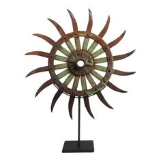 a metal sunflower sculpture on a stand against a white background