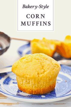 a close up of a muffin on a plate with a spoon in the background