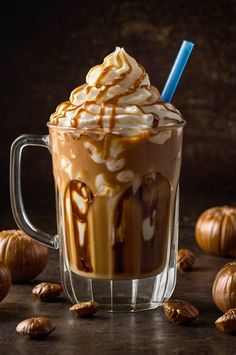 a glass cup filled with whipped cream and caramel on top of a wooden table