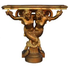 a gold colored statue holding a tray on it's back