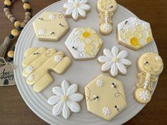 decorated cookies are arranged on a plate next to a bead necklace and bracelets