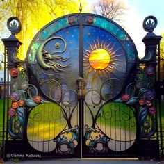 an ornate iron gate with the sun and moon painted on it