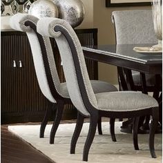 a dining room table and chairs with silver balls on the wall behind them in front of a mirror