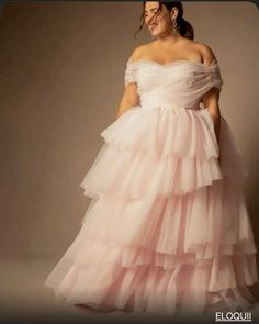 a woman in a pink dress posing for the camera with her hands on her hips