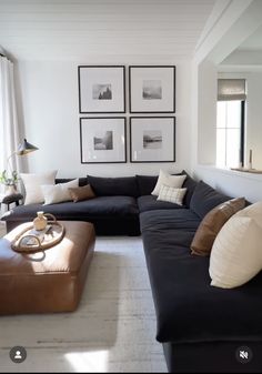 a living room filled with furniture and pictures on the wall above it's windows