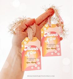 a hand holding two tags that say thank you for celebrating with me and flowers on them