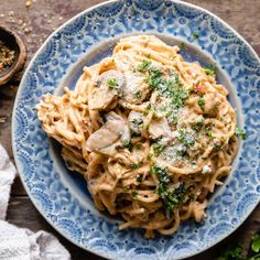 a blue plate topped with pasta covered in sauce and parmesan sprinkles