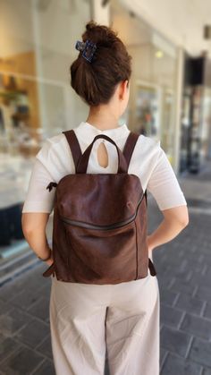 A just-right leather backpack with a minimalist silhouette, this rich - leather backpack features geometric cut with a deep, lined interior with 2 large departments, a zipper pocket, adjustable strap and a antique gold hardware for an chic updated finishing touch. Features: *  1 Interior large zipped pocket * Outside zipper pocket in the back of the bag   * Fully lined with strong Black cotton * 2 departments * Adjustable shoulder strap * zipper closure  ◄ DIMENSIONS ►  Height: 32 cm/ 12.5'' Wid Modern Brown Backpack For On-the-go, Brown Leather Backpack With Zipper Closure, Brown Leather Backpack With Zipper Pocket, Modern Brown Backpack For Everyday Use, Modern Brown Everyday Backpack, Modern Brown Soft Leather Backpack, Modern Brown Backpack For Daily Use, Modern Brown Leather Backpack With Leather Lining, Modern Leather Backpack