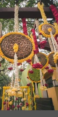 an arrangement of flowers and decorations hanging from a pergolated structure in front of trees