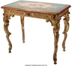 an ornately decorated table with blue and gold paint on the top, sitting against a white background