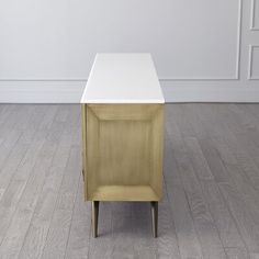 a small white table sitting on top of a hard wood floor next to a wall