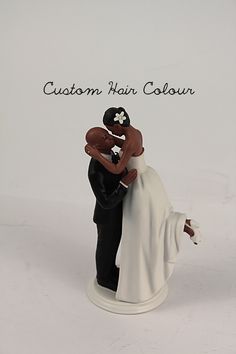 a wedding cake topper with a bride and groom holding each other in their arms