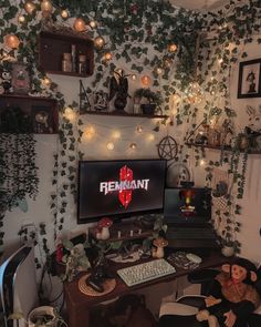 a computer desk with a monitor and keyboard on it in front of a plant covered wall