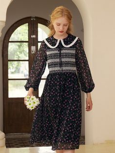 a woman in a black and white dress is holding a flower while walking towards the door