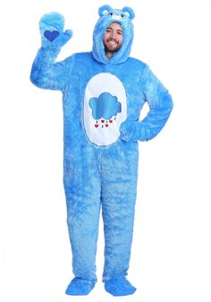 a man in a blue bear costume standing with his hands up to the side and smiling