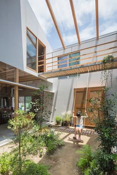 a person sitting on a swing in the middle of a courtyard with trees and plants