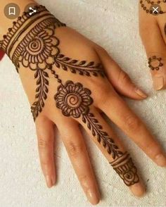 two hands with henna tattoos on them