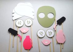 a table topped with paper cut outs and masks on top of each other next to toothpicks