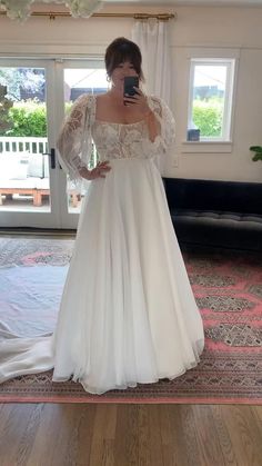 a woman is taking a selfie in her wedding dress while standing on the floor