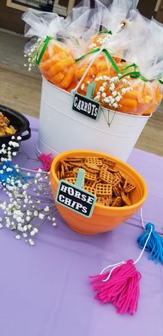 baskets of carrots and other snacks on a purple table cloth with tassels