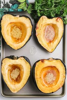 four stuffed acorns sitting on top of a baking pan next to parsley