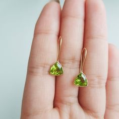 18K Solid Gold Gemstone Earrings ✪Gold weight: 730 milligram ✪Total weight: 1.23 grams ✪Stone size: 7x7 mm ✪Earring size: 8x20 mm ✪Metal: 18k solid yellow gold ✪Gemstone: Natural peridot ✪Setting type: Bezel wire setting If you need any other preferred stone please contact us. QUALITY OF MATERIALS: Metal: Most of our jewelry at JewelryMansion is made with precious metals like gold and silver. These metals are 100% non-allergic to our skin. Gemstone: All of our jewelry is made by handpicked gemst Minimalist Yellow Gold Earrings For May Birthstone, Minimalist Yellow Gold May Birthstone Earrings, Gold Peridot Gemstone Earrings, 14k Gold Green Earrings With Ear Wire, Gold Peridot Earrings For May Birthstone, Gold Peridot Earrings Fine Jewelry, Yellow Gold Peridot Earrings For Gift, Yellow Gold Peridot Dangle Earrings, Minimal Gold Earrings