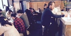 a group of people sitting at tables in a restaurant