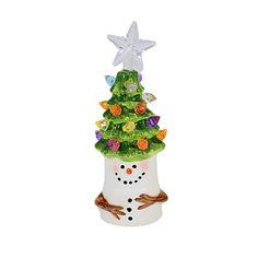 a glass christmas tree in a white vase with a snowman decoration on the top