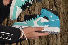 Custom made Jordan 1s. Starts with a gift box blue and fades into a turquoise with a dripping Nike symbol. Shoe represents melting ice. Prices are higher because the base shoes are a lot harder to get as the growing popularity of Jordan 1 mid increases. If you want the same design on a airforce 1 mid just select that option! The picture is just a mock-up and the real shoe will be the same colors as the Jordan 1 mid! Made with Angelus paint, paint is permanent. If you choose to receive a custom b Blue Low-top Sneakers For Gift, Green And Blue Jordans, Airforce 1 Mid, Custom Made Jordans, Nike Air Jordan 1 Mid Blue, Ice Blue Jordan 1 Mid, Nike Jordans Costom Blue 100$, Casual Blue Mid-top Jordan Shoes, Nike Symbol