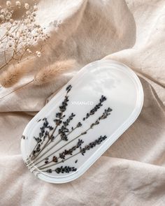 dried lavenders in a white tray on a beige linen covered tablecloth next to dried flowers