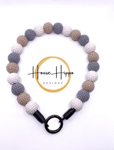 the beaded bracelet is made with grey and white beads, black rubber clasps