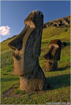 two large rocks sitting on top of a lush green field