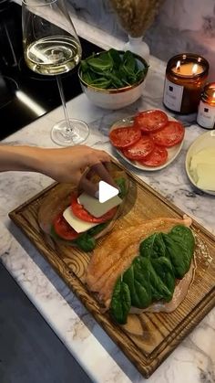 a person cutting up food on top of a wooden cutting board