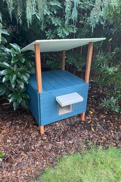 a blue wooden bench in the middle of some bushes