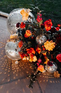 an arrangement of flowers and disco balls on the ground