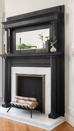 a fireplace with a mirror above it and some logs in front of the fire place