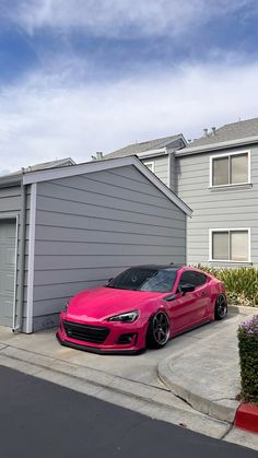 a pink sports car parked in front of a house